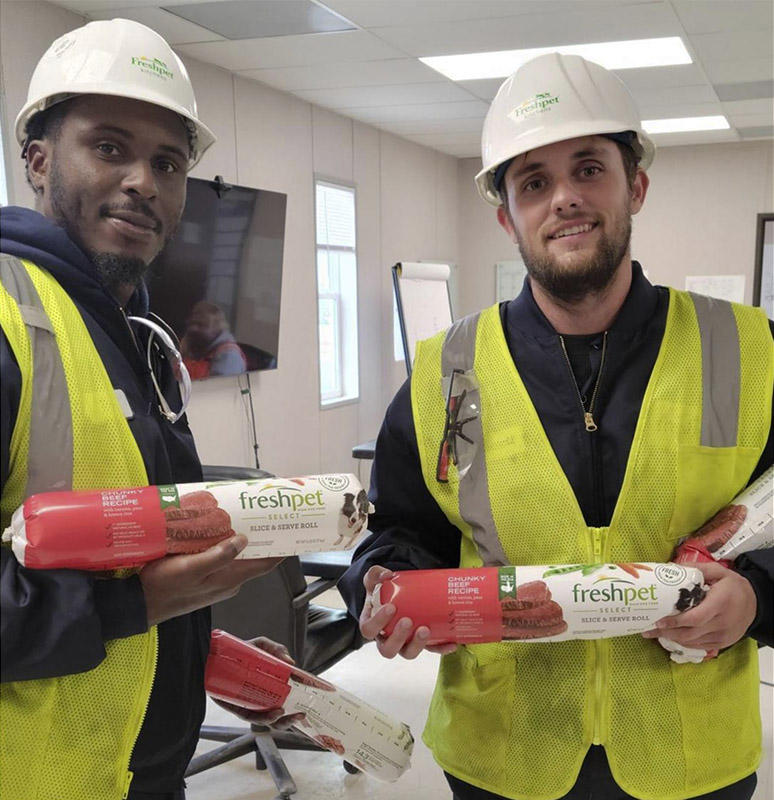 Employees pose with product at Freshpet's new Ennis, Texas, pet food production facility