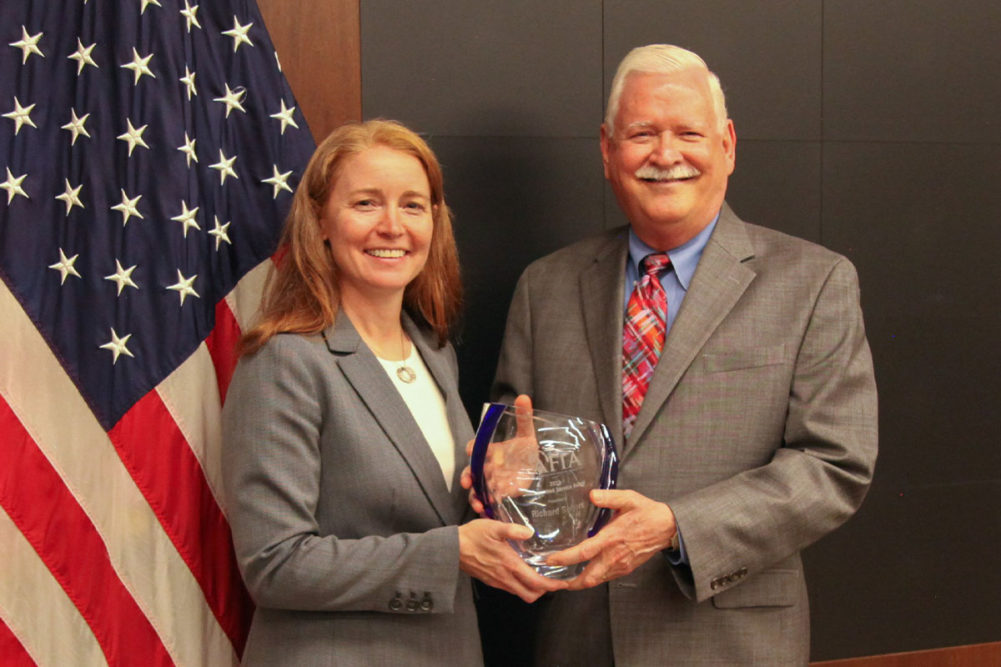Leah Wilkinson, vice president of public policy and education at the AFIA, presenting Richard Sellers with the 2023 Distinguished Service Award