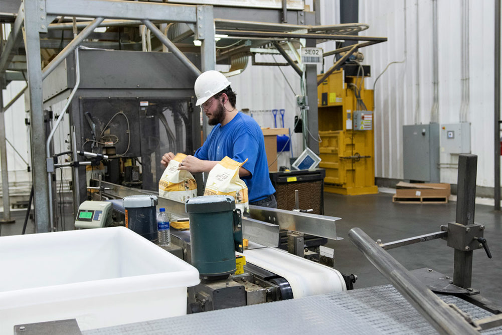 Man works packaging line at pet food co-manufacturing plant