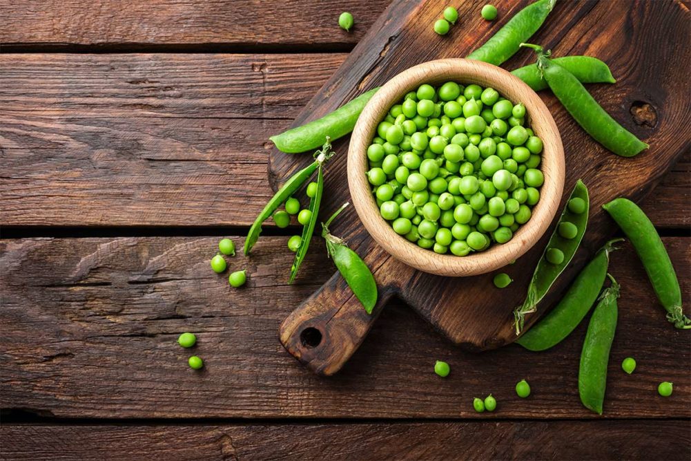 Bowl of peas on wooden table (©STOCKR - STOCK.ADOBE.COM)